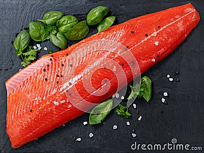 Fresh raw pacific wild sockeye salmon fillet on natural stone with spices and basil leaves Stock Photo