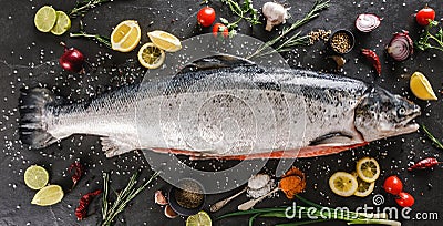 Fresh raw salmon red fish with spices, lemon, pepper, rosemary on dark stone background. Creative layout made of fish, top view, Stock Photo