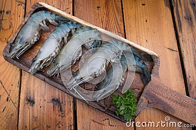 Fresh raw Tiger Prawn on wooden plate Stock Photo