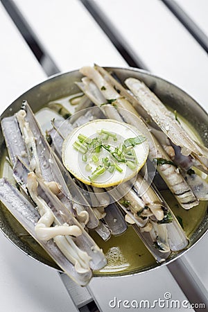 Fresh razor shell seafood steamed in garlic herb wine sauce Stock Photo