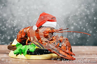 Fresh red lobster with christmas hat shellfish cooked in the seafood restaurant - Steamed lobster dinner food on wooden christmas Stock Photo