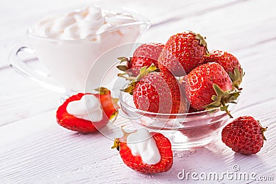 Fresh red strawberries with cream on the white wooden table. Stock Photo