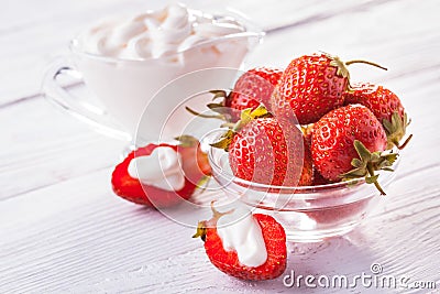 Fresh red strawberries with cream on the white wooden table. Stock Photo