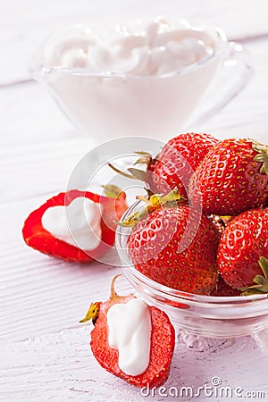 Fresh red strawberries with cream on the white wooden table. Stock Photo