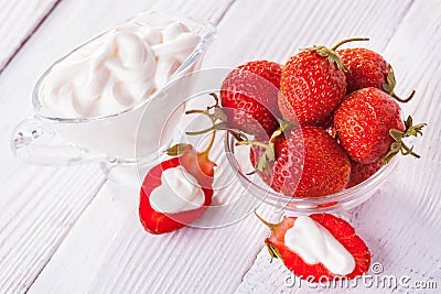 Fresh red strawberries with cream on the white wooden table. Stock Photo