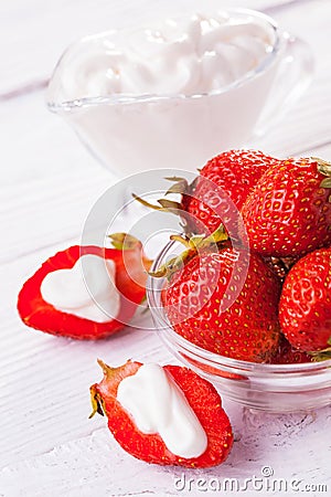 Fresh red strawberries with cream on the white wooden table. Stock Photo