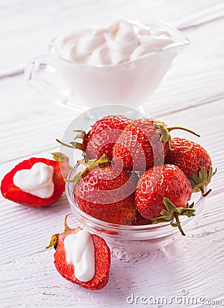 Fresh red strawberries with cream on the white wooden table. Stock Photo