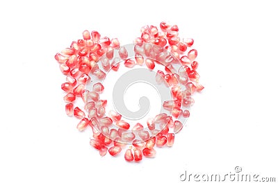 fresh ripe juicy grains Pomegranate, (Punica granatum) seeds arranged heart shape isolated a white backdrop Stock Photo
