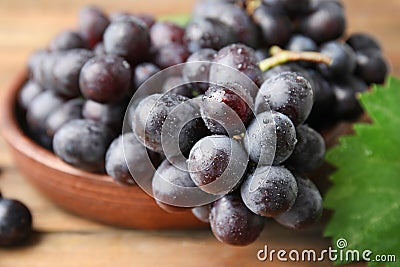 Fresh ripe juicy grapes in bowl on table Stock Photo