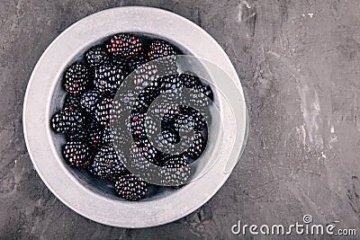 Fresh ripe organic blackberries in a bowl on a wooden background Stock Photo