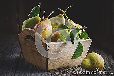 Fresh ripe pears in a wooden crate on table. Stock Photo