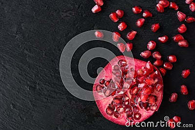 Fresh ripe pomegranate fruit on wet black stone vintage background Stock Photo