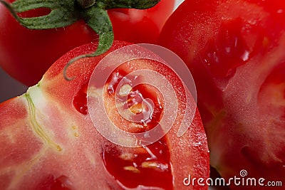Fresh, ripe tomato, cut in half, juicy, still with green stem Stock Photo