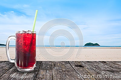 Fresh Roselle juice sweet water and ice in glass iced coffee on table wooden with beach landscape view nature background ,Summer Stock Photo