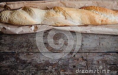Fresh rosy baguettes on a dark wooden retro background. Top view, copy space Stock Photo