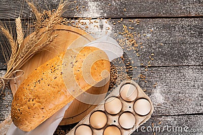 Fresh rural bread loaf with spikelets of wheat on a wooden background Stock Photo