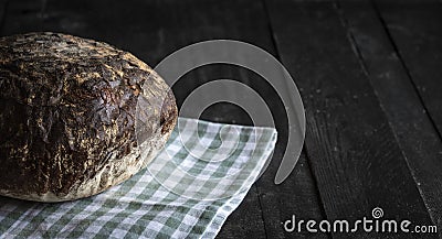 Fresh rye bread on black wooden table Stock Photo