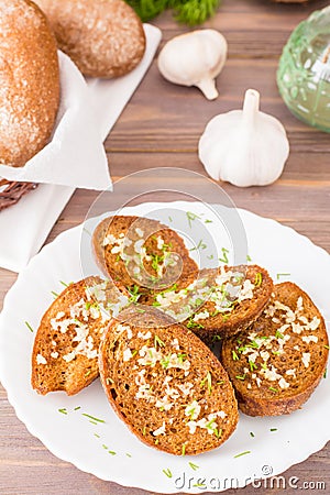 Fresh rye garlic croutons with dill on a plate and buns Stock Photo