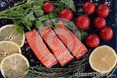 fresh salmon steakes with greenery, lemon and cherry tomatoes Stock Photo