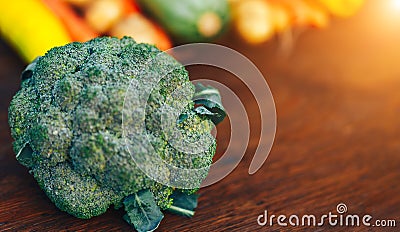 Fresh salubrious colourful vegetables on wooden background, broccoli in focus, potatoes, carrots, zucchini unfocused, selected Stock Photo