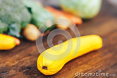 fresh salubrious colourful vegetables on wooden background, squash in focus, potatoes, carrots, broccoli, zucchini unfocused, Stock Photo