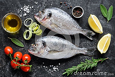 Fresh sea fish Dorado or Sea Bream with herbs and spices on slate background ready for cooking Stock Photo