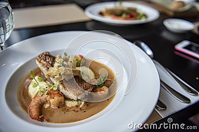 Fresh sea food menu with red snapper, shrimp, potato and topped with brown gravy. Stock Photo