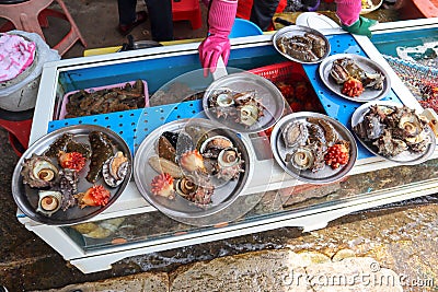 Fresh sea foods on the plates next to beach Stock Photo