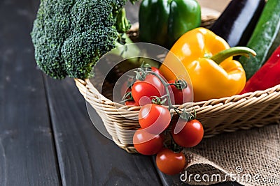 Fresh seasonal vegetables in basket on rustic wooden table Stock Photo