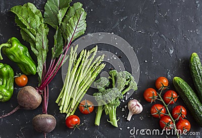 Fresh seasonal vegetables - beetroot, asparagus, broccoli, tomatoes, peppers, cucumbers on a dark background. Healthy food concept Stock Photo