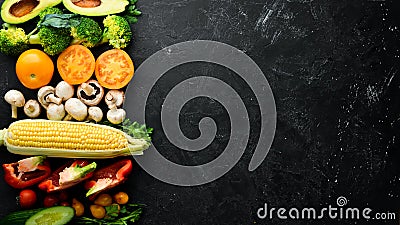 Fresh seasonal vegetables on a black stone background: Pumpkin, tomato, avocado, cucumber, onion, carrot. Autumn food. Stock Photo