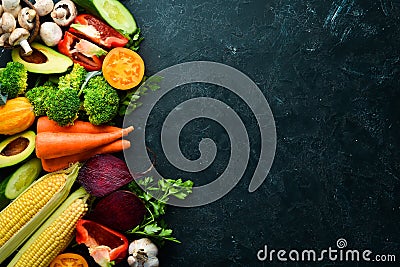 Fresh seasonal vegetables on a black stone background: Pumpkin, tomato, avocado, cucumber, onion, carrot. Stock Photo