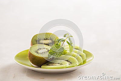 Fresh sliced kiwi on plate. Green Kiwi fruit slices on white wooden background. Copy space. Kiwi cuted on plate Stock Photo