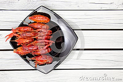Fresh steamed crawfish on the black rectangular plate on the white wooden background Stock Photo