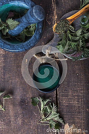 Fresh stinging nettle leaves on wooden table.Urtica dioica oil with spirulina powder, a healthy supplement to improve health Stock Photo