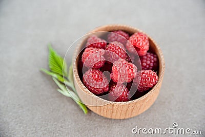 Fresh summer raspberry in a wooden bowl. Selective focus. Stock Photo