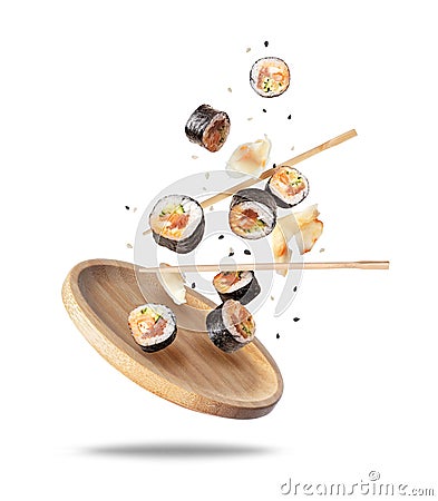 Fresh sushi rolls with ginger falling on a wooden plate Stock Photo