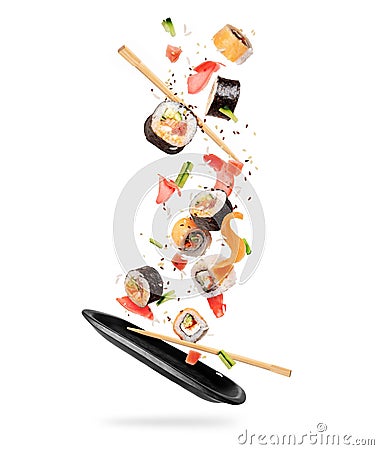 Fresh sushi rolls with various ingredients falling on a black clay plate Stock Photo