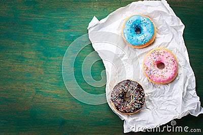 Fresh sweet colorful homemade donuts on a green wooden vintage background for birthday or party Stock Photo