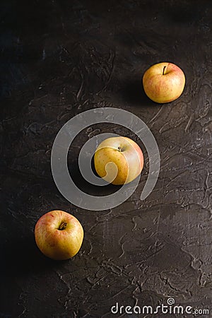 Fresh sweet three apples in row on dark black textured background Stock Photo
