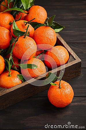 Fresh tangerine clementine with leaves on dark wooden background Stock Photo