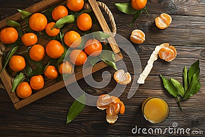 Fresh tangerine oranges on a wooden table. Peeled mandarin. Halves, slices and whole clementines closeup. Stock Photo