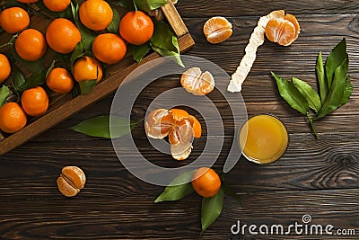 Fresh tangerine oranges on a wooden table. Peeled mandarin. Halves, slices and whole clementines closeup. Stock Photo