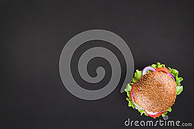 Fresh tasty burger Top view on black background. Tasty and appetizing cheeseburger. Vegetarian burger with place for Stock Photo