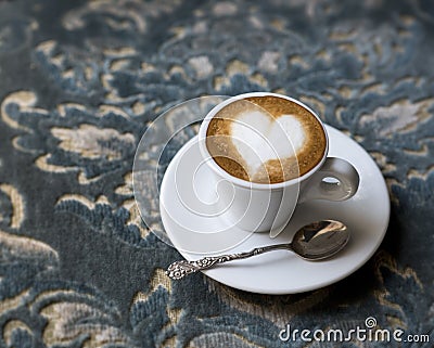 Fresh tasty espresso cup of hot coffee with coffee beans on a blue antique background. Drawing on coffee - heart. Copy space Stock Photo