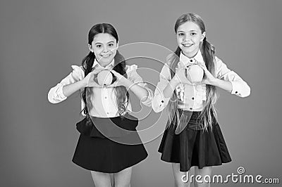 Fresh and tasty. Small girls eating natural vitamin food. Cute schoolgirls holding apples. School children with healthy Stock Photo