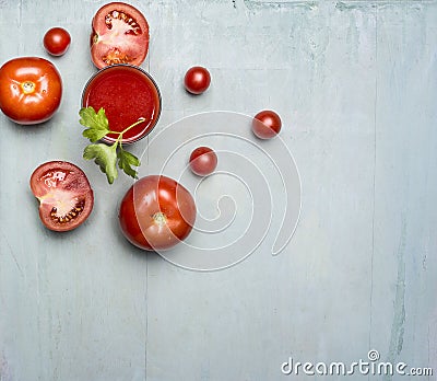 Fresh tomato juice in a glass with a straw, with green leaf, chopped tomatoes spread around border ,text area wooden rusti Stock Photo