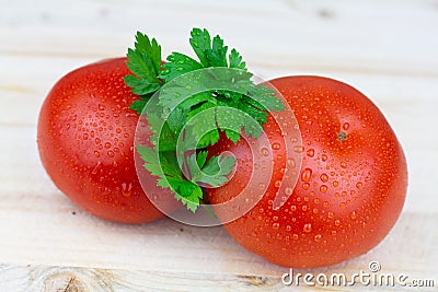 Fresh tomatoes with waterdrops and parsley on a wooden table Stock Photo