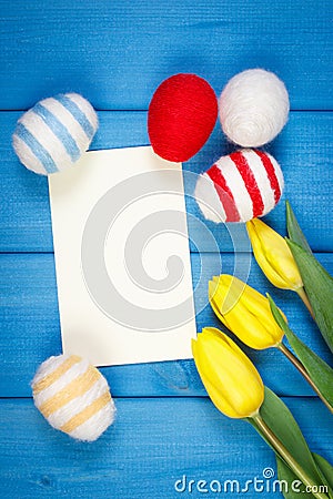 Fresh tulips and Easter eggs wrapped woolen string, Easter decoration, copy space for text on sheet of paper Stock Photo