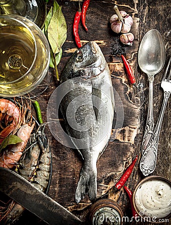 Fresh unprepared Dorado fish with wine, herbs and spices. Stock Photo